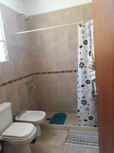 y baño con aseo y cortina de ducha. en Casa en Villa Allende Lomas en Villa Allende
