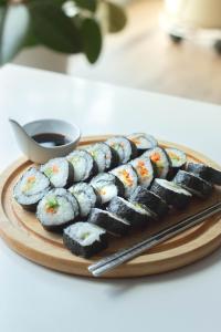 a plate of sushi on a table with a plate of soy sauce at Baliku Dive Resort in Amed