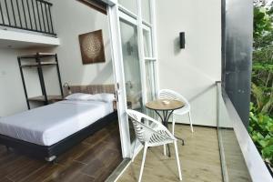 Schlafzimmer mit einem Bett, einem Tisch und Stühlen in der Unterkunft Negla Beach Villa in Godog