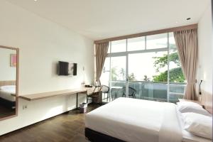 a bedroom with a bed and a desk and a window at Negla Beach Villa in Godog