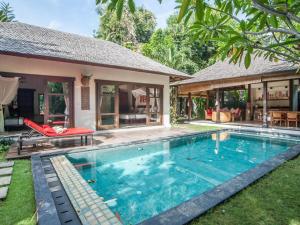 una piscina frente a una villa en Mango Tree Villas, en Jimbaran