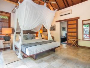 
a bedroom with a bed and a canopy at Mango Tree Villas in Jimbaran
