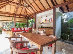 
a dining room table with chairs and umbrellas at Mango Tree Villas in Jimbaran
