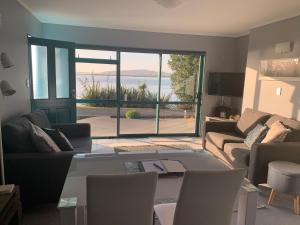 a living room with a view of the ocean at Beach Lane Apartment in Whangarei