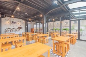 an empty restaurant with wooden tables and benches at RedDoorz Premium @ Hotel Hebat in Bandung