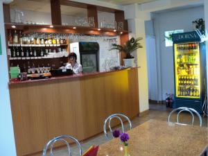a woman standing behind a bar in a restaurant at Randevú Panzió in Miercurea-Ciuc