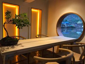 stół z doniczką i okrągłym lustrem w obiekcie Lee Wine Ruk Thai Resort w mieście Ban Rak Thai