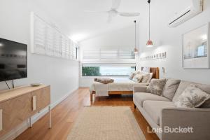 a living room with a couch and a tv at The Lennoxhaus in Lennox Head