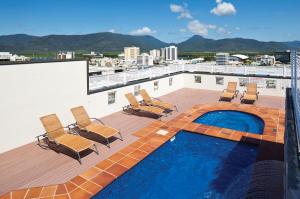 einen Balkon mit Stühlen und einen Pool auf einem Gebäude in der Unterkunft Cairns Central Plaza Apartment Hotel Official in Cairns