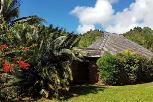 a house with a palm tree in front of it at Villa Anuanua by Tahiti Homes in Papetoai