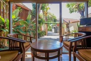 a room with a table and chairs on a balcony at OYO 2581 Ketut Smile in Denpasar