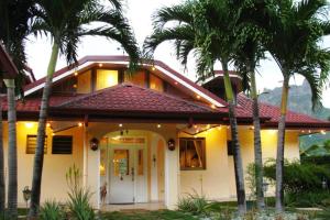 a house with palm trees in front of it at Villa Oramarama in Paopao