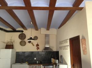 Casa Rural Pico Espadan في Almedíjar: مطبخ بسقف مع عوارض خشبية