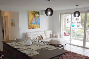 a living room with a white couch and a table at City'appart in Papeete
