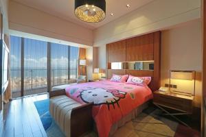 ein Schlafzimmer mit einem großen Bett mit einer rosa Tagesdecke in der Unterkunft Xiamen International Conference Center Hotel Prime Seaview Hotel in Xiamen