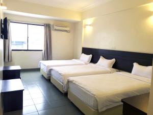 een hotelkamer met 2 bedden en een raam bij Hotel Sitiawan in Sitiawan