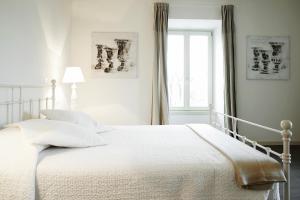 a white bedroom with a bed and a window at Porta Nuova Bergamo Apartments CIM123 in Bergamo