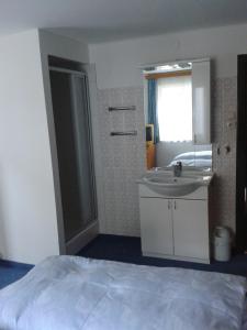 une salle de bain avec un lit, un lavabo et un miroir dans l'établissement Haus Znopp, à Saalbach-Hinterglemm