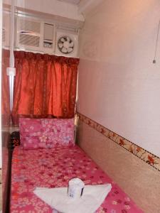 a small room with a pink bed and a window at Dutch Hostel in Hong Kong