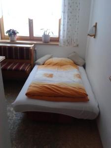 un lit dans une petite pièce avec une fenêtre dans l'établissement Haus Znopp, à Saalbach-Hinterglemm