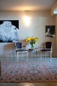 a room with two chairs and a table with a vase of flowers at Hotel Italia in Noli