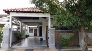 a white house with a porch and a tree at Carols Guesthouse near Jonker and Satay Celup in Malacca