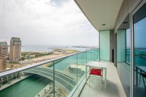 a red chair sits on the balcony of a building at Ultra modern 1BD in Damac Heights Marina in Dubai