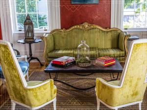 a living room with a green couch and a table at Argos Inn - Ithaca's Boutique Hotel in Ithaca