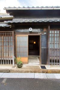 un accès à un bâtiment asiatique avec une porte dans l'établissement Kitahama Sumiyoshi, à Takamatsu