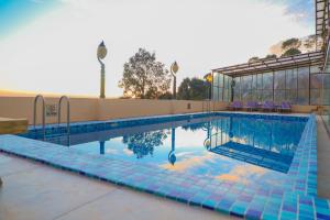 a large swimming pool with blue tiles on a building at Asia Spa Resort in Dharamshala +26 photos