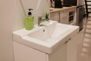 een witte wastafel met een groene fles erop bij S1 Large Duplex Silom 3 Beds, Full Kitchen WIFI in Bangkok +23 foto's