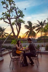 a man and woman sitting at a table with a plane at d'primahotel Airport Jakarta 2 in Tangerang