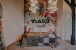 a bedroom with a bed with a sign on the wall at Hotel Trash Deluxe in Maastricht