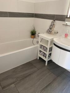 ein Badezimmer mit einer weißen Badewanne und einem Waschbecken in der Unterkunft Ferienwohnung " Haus am Meer " in Bad Zwischenahn