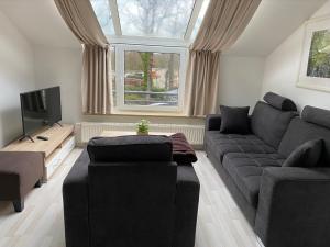 ein Wohnzimmer mit einem Sofa und einem TV in der Unterkunft Ferienwohnung " Haus am Meer " in Bad Zwischenahn