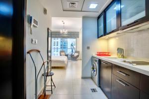 a kitchen with a sink and a washing machine at Cute Dubai Marina Studio in Skyview Tower in Dubai