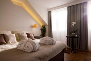 - une chambre avec des serviettes sur un lit et une fenêtre dans l'établissement Art de Sejour - B&B, à Bruxelles