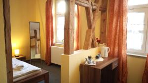 Zimmer mit Spiegel, Bett und Fenster in der Unterkunft Gasthof Zur Rose in Weimar