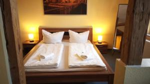 a bedroom with two beds with white sheets and towels at Gasthof Zur Rose in Weimar