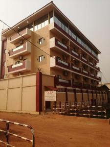 a large building with a fence in front of it at La Couronne Suites in Bangui