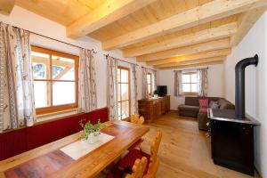 a living room with a wooden table and a fireplace at Almliesl HUET-484 in Hüttschlag