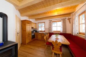 eine Küche mit einem roten Sofa und einem Holztisch in der Unterkunft Almliesl HUET-484 in Hüttschlag