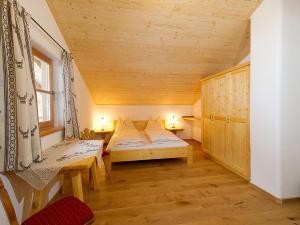 um pequeno quarto com uma cama e um tecto de madeira em Almliesl HUET-484 em Hüttschlag