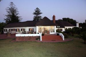 a large white house with a staircase in front of it at The Sanctuary Guest House Estate in Cape Town