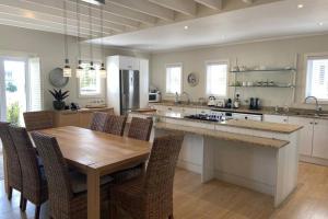 a large kitchen with a wooden table and chairs at Summit Song - Thesen Island in Knysna