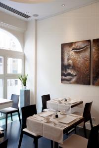 une salle à manger avec des tables et un tableau mural dans l'établissement Art de Sejour - B&B, à Bruxelles