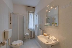 a white bathroom with a sink and a toilet at Hotel Massimo in Marina di Cecina