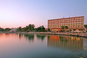 a large building sitting next to a body of water at Crowne Plaza Limassol by IHG in Limassol