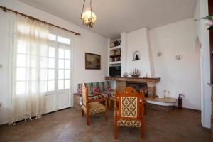 sala de estar con mesa, sillas y chimenea en Giameiko Traditional House Kalymnos, en Kalymnos