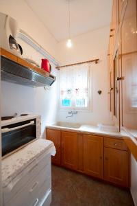 a kitchen with wooden cabinets and a sink and a window at Giameiko Traditional House Kalymnos in Kalymnos +16 photos